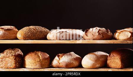 Verschiedene Brote auf Holzregalen Stockfoto