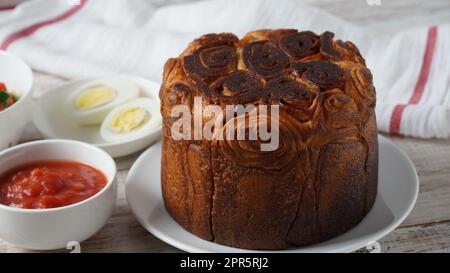 Kubaneh – Jemenitisches jüdisches Brot, Brioche-Brot – wird am Shabbat-Morgen serviert, serviert mit einem Dip aus zerkleinerten Tomaten und hart gekochten Eiern Stockfoto