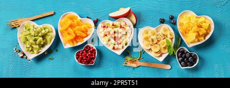 Verschiedene reife Früchte in Schalen auf dem Tisch Stockfoto