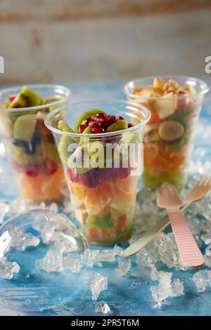 Plastikbecher mit verschiedenen Früchten Stockfoto