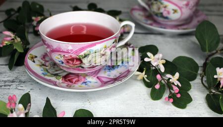 Zwei Tassen Tee mit Blumen auf einem Holztisch Stockfoto