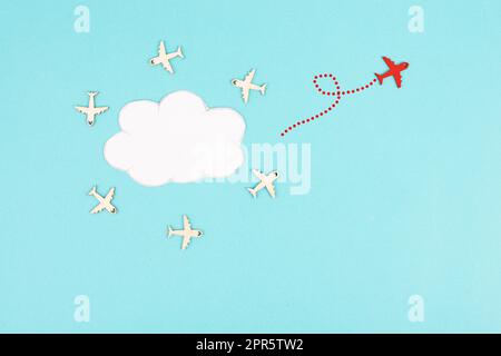 Flugzeuggruppe, die in einem Kreis um eine Wolke fliegt, rotes Flugzeug denkt anders und nimmt die entgegengesetzte Richtung, gegen den Fluss symbolisch, Mut und Siegerkonzept Stockfoto