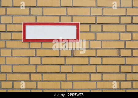 Leeres weißes Schild mit Text Freiraum auf Ziegelwand Stockfoto
