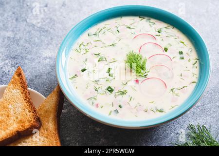 Sommerliche Yoghurt-Suppe mit Rettich, Gurke, Kartoffel und Wurst. Okroschka. Sommerliche kalte Suppe. Stockfoto