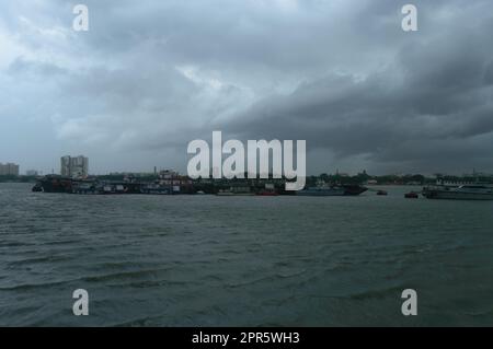 Fähren, die an einem dramatisch bewölkten Tag in der Ferne über dem Ganges River schweben. Schöner Landschaftshorizont von Babu Ghat. Kalkutta Westbengalen Indien Südasien 19. Juni 2022 Stockfoto