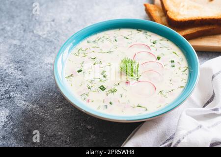 Sommerliche Yoghurt-Suppe mit Rettich, Gurke, Kartoffel und Wurst. Okroschka. Sommerliche kalte Suppe. Stockfoto