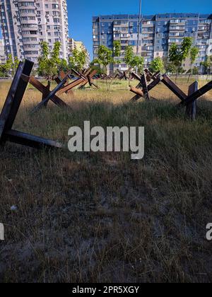 Eiserne Panzerabwehrstrukturen auf dem Hintergrund von Stadtgebäuden. Stockfoto