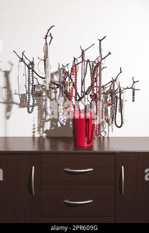 Der originale Halter für Schmuck in Form eines Baumes, handgefertigt. Produkte mit Dekorationen auf der Kommode. Inneneinrichtung, originelle Idee. clos Stockfoto