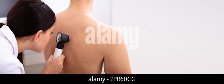 Doktor untersucht pigmentierte Haut am Rücken des Mannes Stockfoto