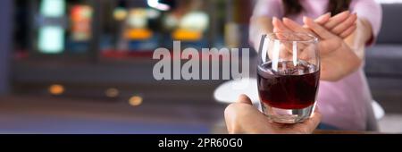 Frau Lehnt Ein Glas Getränk Ab, Das Von Einer Person Angeboten Wird Stockfoto