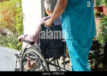 Pflegekraft helfen und pflegen asiatische Seniorin oder ältere Frau Frau Patient sitzt im Rollstuhl auf der Rampe am Krankenpflegekrankenhaus, gesund stark medizinisches Konzept Stockfoto