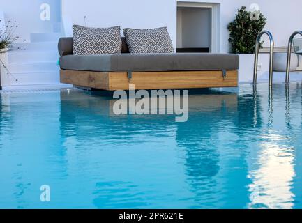 Ein breites Bett am Pool, der perfekte Ort für einen erholsamen Urlaub Stockfoto