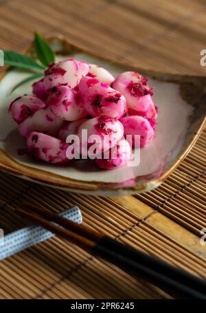 Eingelegter Shiso-Bonito-Knoblauch, serviert auf einem Teller auf einer Bambus-Lunch-Matte. Stockfoto