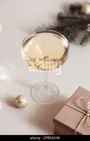 Ein Glas Champagner, eine Geschenkbox und ein Fichtenzweig. Weihnachten, Neujahr Stockfoto