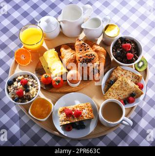 Frühstück serviert mit Kaffee, Saft, Croissants und Obst Stockfoto