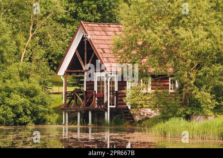 Rote Ferienhütte mit Reflexion im Teich Stockfoto