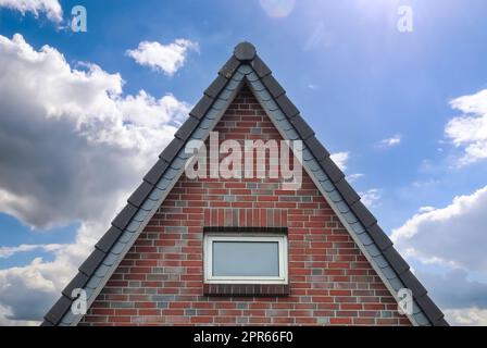 Dachfenster im Velux-Stil mit dunklen Dachziegeln. Stockfoto