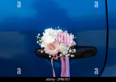 Hochzeitsblende am Griff eines blauen Autos Stockfoto