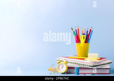 Viele verschiedene Schulen, Bürobedarf auf einem Holztisch auf grünem Hintergrund Stockfoto