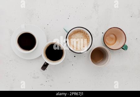 Draufsicht auf flachem Untergrund mit vielen verschiedenen vollen und leeren Kaffeetassen auf Beton Stockfoto