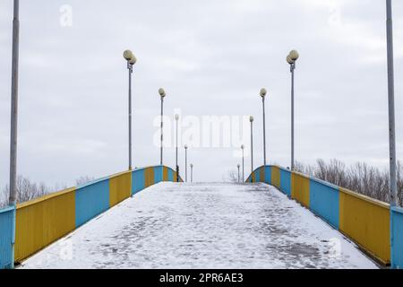 Fußgängerbrücke in Tschernihiv über den Fluss Desna im Schnee an einem Winterschneetag. Stockfoto