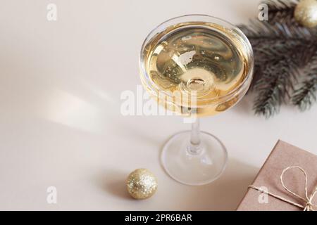 Ein Glas Champagner, eine Geschenkbox und ein Fichtenzweig. Weihnachten, Neujahr Stockfoto