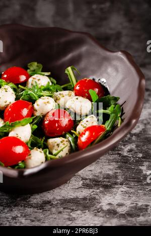Caprese-Salat. Frische Rucola, Kirschtomaten, saftige Mini-Mozzarella und ein Dressing aus Orangano und Olivenöl Stockfoto