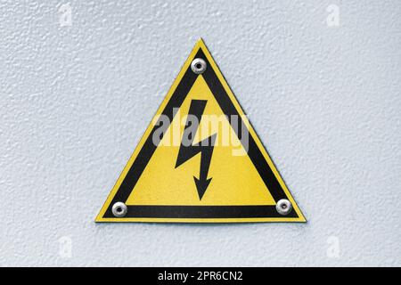 Dreieckiges gelbes Zeichen für gefährliche elektrische Spannung Stockfoto