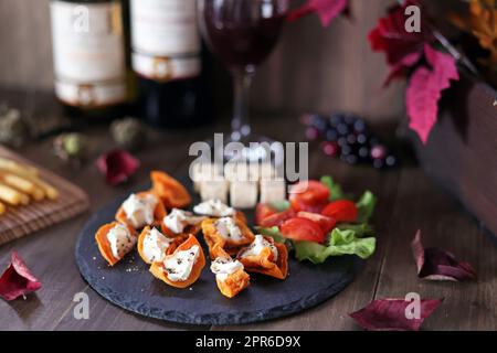 Getrocknete Persimone und Frischkäse mit Hors d'Oeuvre und Wein Stockfoto