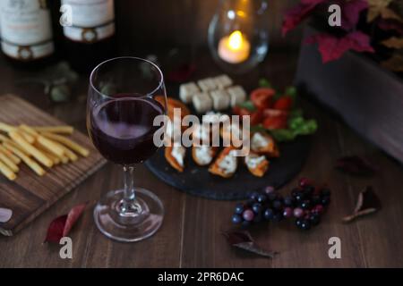 Getrocknete Persimone und Frischkäse mit Hors d'Oeuvre und Wein Stockfoto