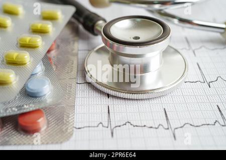 Stethoskop im Elektrokardiogramm (EKG) mit Medikament, Herzwelle, Herzinfarkt, Kardiogrammbericht. Stockfoto