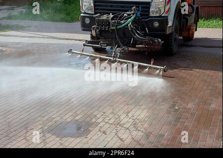 Eine spezielle Maschine wäscht Stadtwege und Straßen mit Wasser Stockfoto