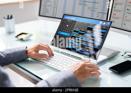 Mitarbeiter, Der Am Kalenderplan Arbeitet Stockfoto
