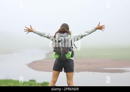 Rückblick auf einen Wanderer, der sich in den Bergen ausstreckt Stockfoto