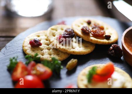 Vorspeisen und Snacks, Cracker, getrocknete Früchte, Tomaten und Petersilie Stockfoto