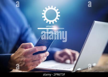 Mann, Der Software-Update Auf Dem Mobiltelefon Durchführt Stockfoto