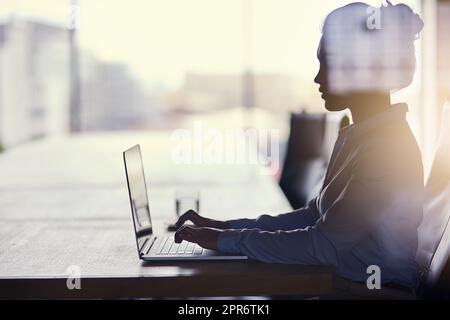 Große Träume erfordern harte Arbeit. Eine kurze Aufnahme einer Geschäftsfrau, die im Büro an ihrem Laptop arbeitet. Stockfoto