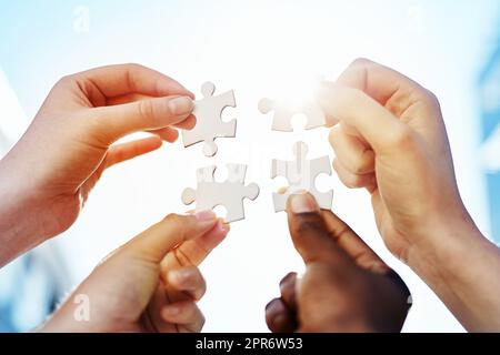 Verbinden der Teile. Schuss von Händen, die Puzzleteile zusammenfügen. Stockfoto