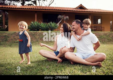 Unsere Kinder erhellen alle unsere Tage. Aufnahme einer glücklichen Familie, die sich im Freien verbindet. Stockfoto