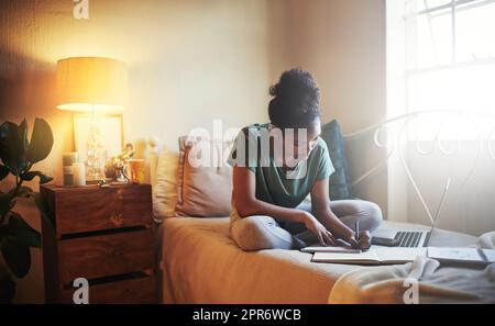 Scheut einen fleißigen Schüler. Ganzkörperaufnahme einer jungen Studentin, die zu Hause studiert. Stockfoto