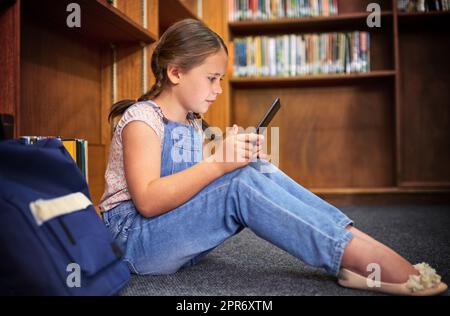 Scheut einen hellen jungen Geist. Aufnahme eines jungen Mädchens mit einem digitalen Tablet in der Schule. Stockfoto