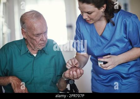 Widmet sich der persönlichen Qualitätspflege. Aufnahme einer Krankenschwester, die ihrem älteren Patienten hilft. Stockfoto