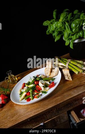 Spargelsalat mit Erdbeeren, Tomaten und Ziegenkäse Stockfoto