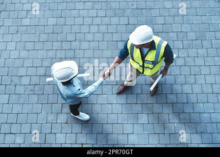 Ich kann es kaum erwarten, dieses Projekt mit Ihnen zu beginnen. Aufnahme von zwei Ingenieuren, die sich die Hände schüttelten. Stockfoto