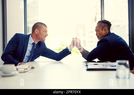 Die Herausforderung ist an. Aufnahme von zwei Geschäftsleuten, die in einem Büro Armringen. Stockfoto