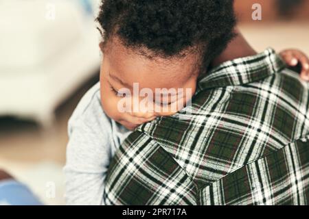 Schlaf löst alles. Aufnahme eines entzückenden Jungen, der auf den Schultern seiner Mutter einschläft. Stockfoto