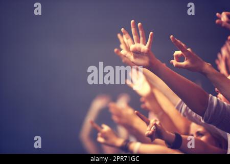 Genießen Sie jeden Song, den die Band spielt. Ausgeschnittene Aufnahme einer Menge bei einem Konzert. Stockfoto