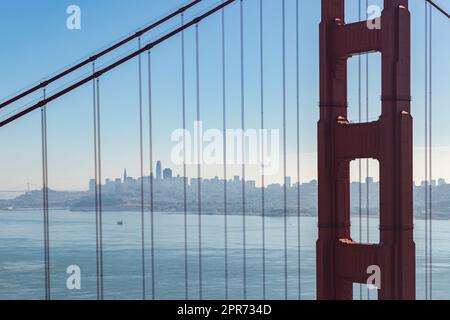 Ein Bild der Kabel der Golden Gate Bridge und der Stadt San Francisco in der Ferne. Stockfoto