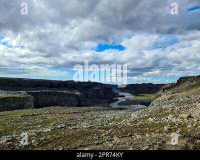 Fantastische Landschaft mit fließenden Flüssen und Bächen mit Felsen und Gras in Island. Stockfoto