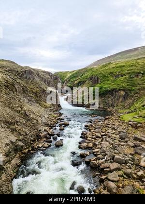 Fantastische Landschaft mit fließenden Flüssen und Bächen mit Felsen und Gras in Island. Stockfoto